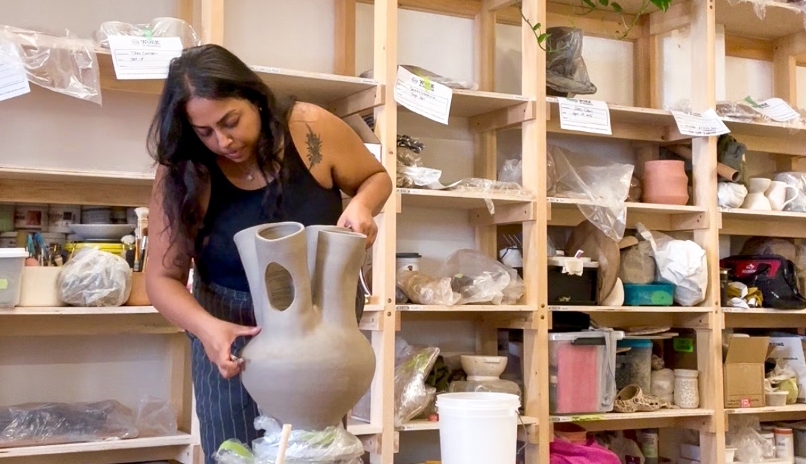 Piya hand-building a tall vessel in the studio